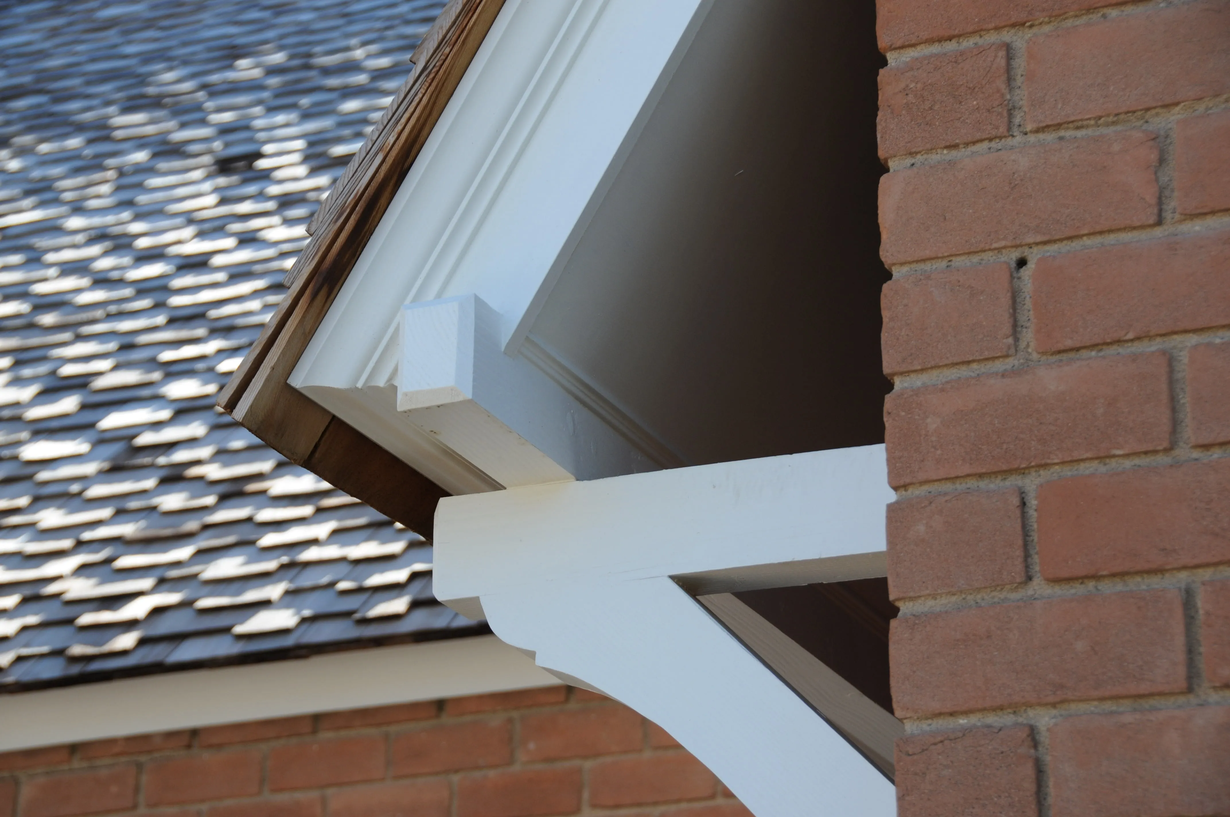 Porch bracket and eave detail on a brick cottage renovation